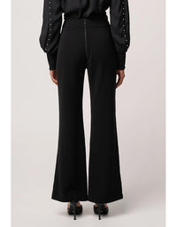 Black high-waisted pants worn by a person on a light gray background
