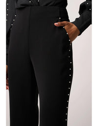 Black pants with pearl buttons on a white background