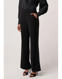 Black outfit with studded details on a light gray background