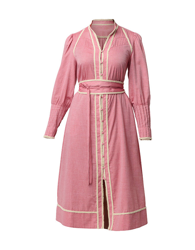 A pink long-sleeve midi dress with cream-colored trim and a matching waist tie belt, shown on a plain white background.