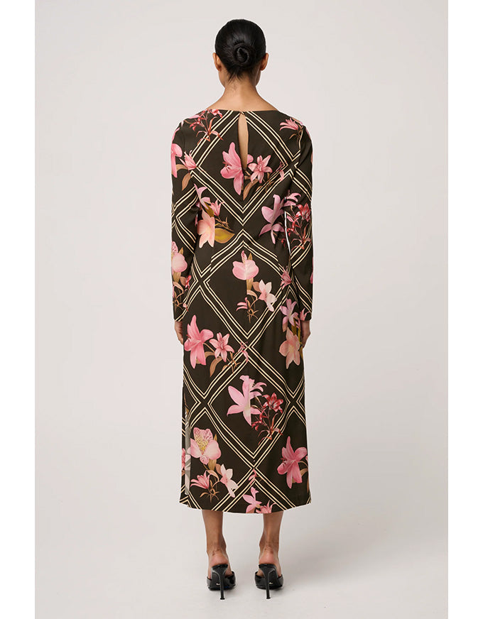 Woman wearing a long floral dress with geometric pattern on a white background