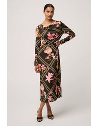 Woman wearing a floral patterned dress on a plain background