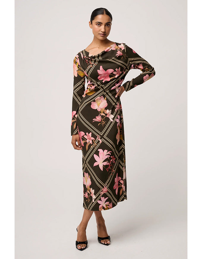 Woman wearing a floral patterned dress on a plain background