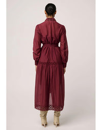 Maroon dress with lace details worn by a person on a light gray background