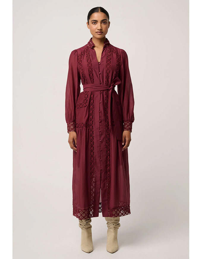 Woman wearing a burgundy lace dress on a white background