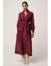 Woman wearing a burgundy lace dress on a white background