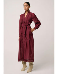 Woman wearing a burgundy dress with lace details on a white background