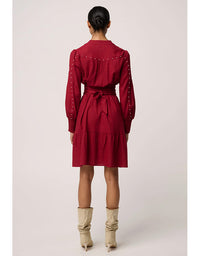 Red dress with long sleeves and a belt worn by a person on a white background