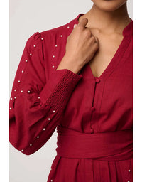 Red dress with pearl details on a white background