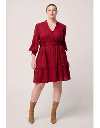 Woman wearing a red dress with a plain background