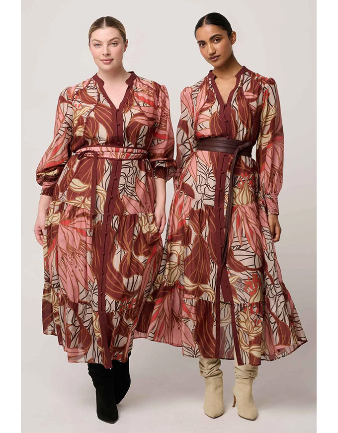 Two women wearing patterned dresses standing side by side on a white background