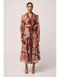 Woman wearing a patterned dress on a plain background