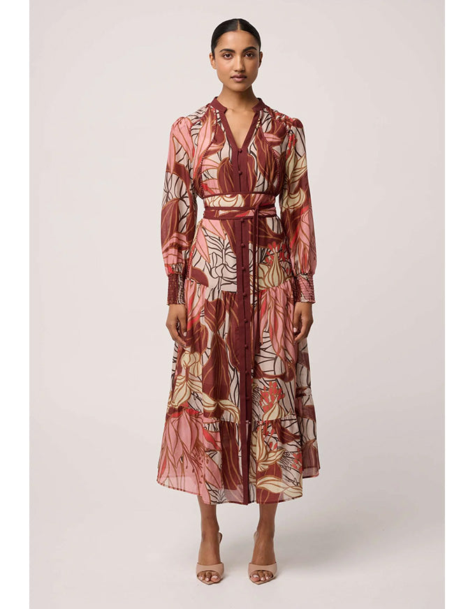 Woman wearing a patterned dress on a plain background