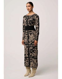 Woman wearing a black and beige patterned outfit on a white background