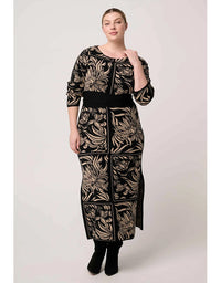 Woman wearing a black and gold patterned outfit on a white background