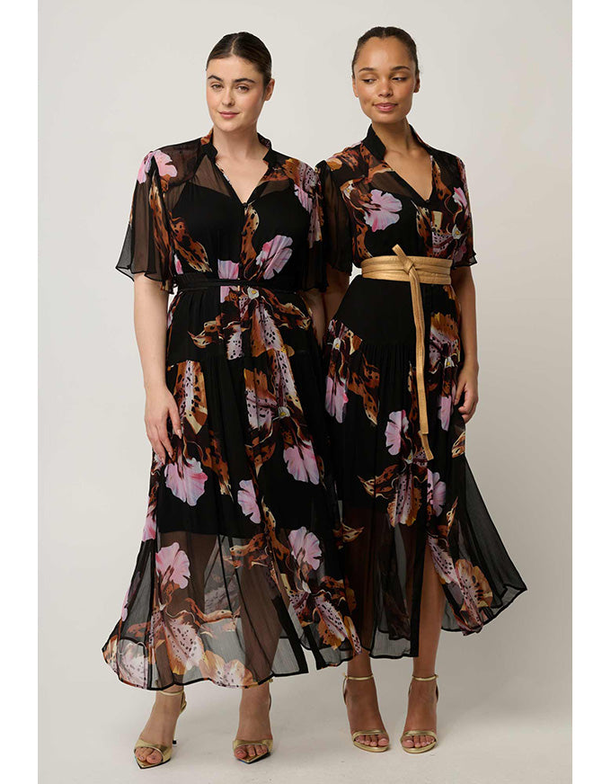 Two women modeling matching black midi dresses with a pink, purple, and brown floral print. The dress on the left has sheer flutter sleeves and a self-tie waist, while the dress on the right features a gold belt at the waist.