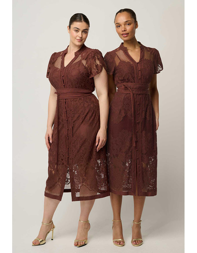 Two women modeling matching brown lace midi dresses with short sleeves, V-necklines, and self-tie waistbelts against a plain light gray studio background.