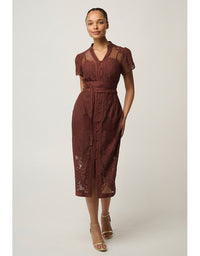 A woman modeling a rust-brown lace midi dress with sheer short sleeves, a V-neckline, and a matching waist tie, set against a plain light gray studio background.