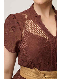 Close-up of a woman wearing a brown lace short-sleeve top with a tan belt, cropped from the lower face to the waist against a plain light background.