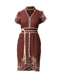 A brown short-sleeve dress with cream-colored trim, a matching waist tie belt, and floral embroidery details on the sleeves and hem, shown against a plain white background.