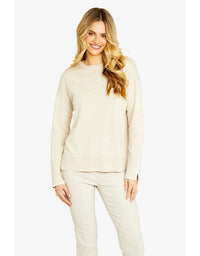Woman wearing a beige sweater and pants on a white background