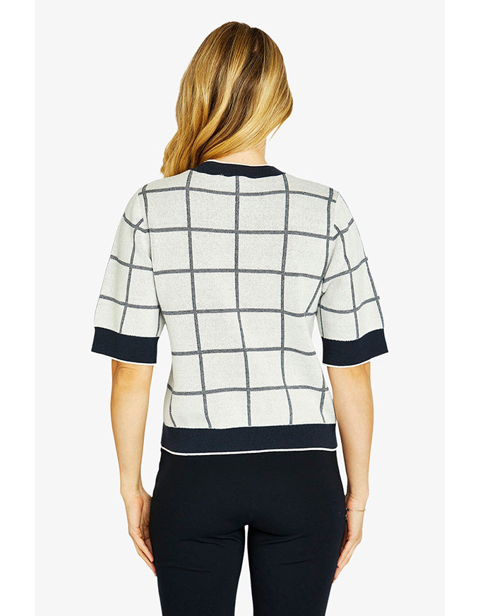 Woman wearing a checkered shirt with black accents on a white background