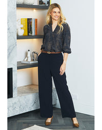 Woman in a stylish outfit standing in a modern interior setting