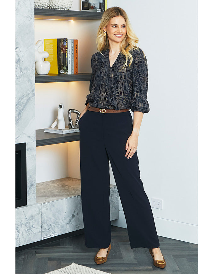Woman in a stylish outfit standing in a modern interior setting