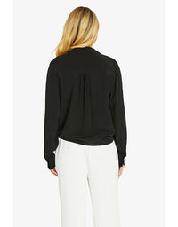 Woman wearing a black blouse and white pants on a white background