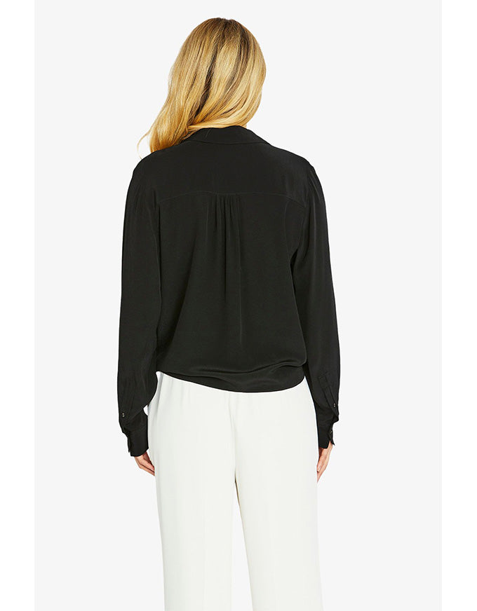 Woman wearing a black blouse and white pants on a white background