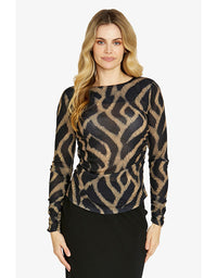 Woman wearing a black and gold patterned top on a white background