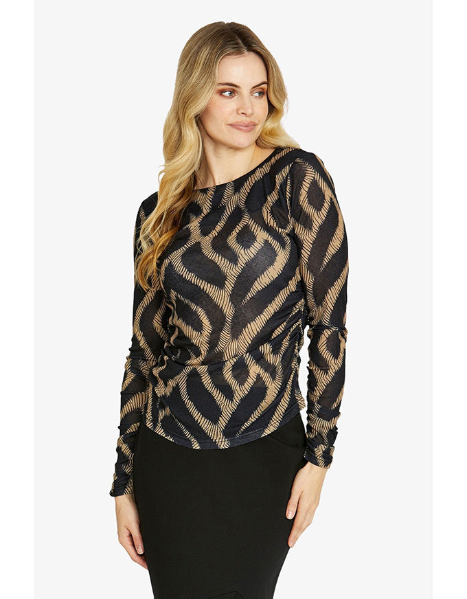 Woman wearing a black and gold patterned blouse on a white background