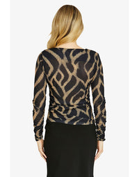 Woman wearing a black and gold patterned top with long sleeves on a white background
