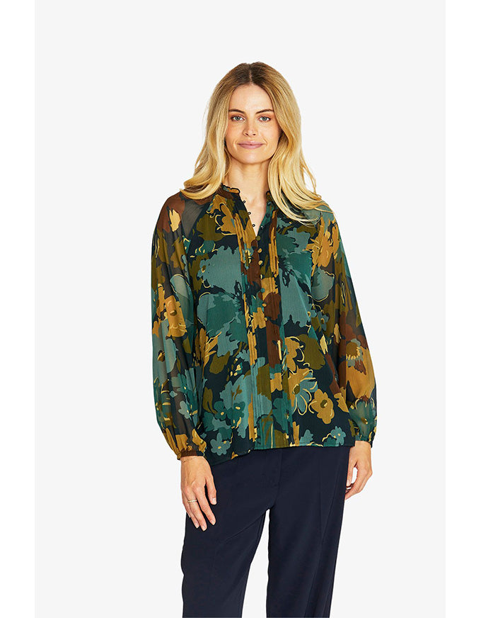 Woman wearing a patterned blouse with a white background