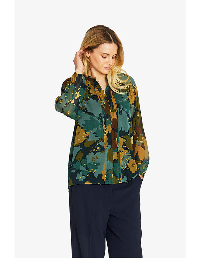 Woman wearing a floral patterned shirt on a white background