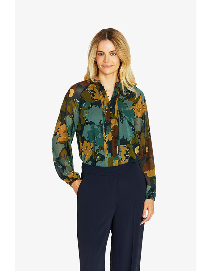 Woman wearing a camouflage-patterned blouse with long sleeves on a white background