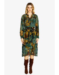 Woman wearing a green floral dress with brown knee-high boots on a white background