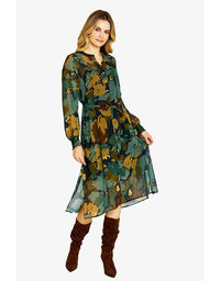Woman wearing a long-sleeve, floral-patterned dress with brown knee-high boots on a white background
