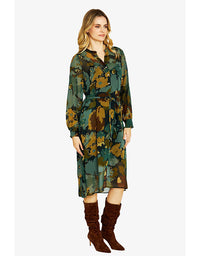 Woman wearing a green floral dress with brown boots on a white background