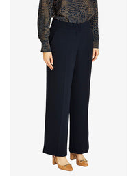 Person wearing navy wide-leg pants with a patterned top on a white background