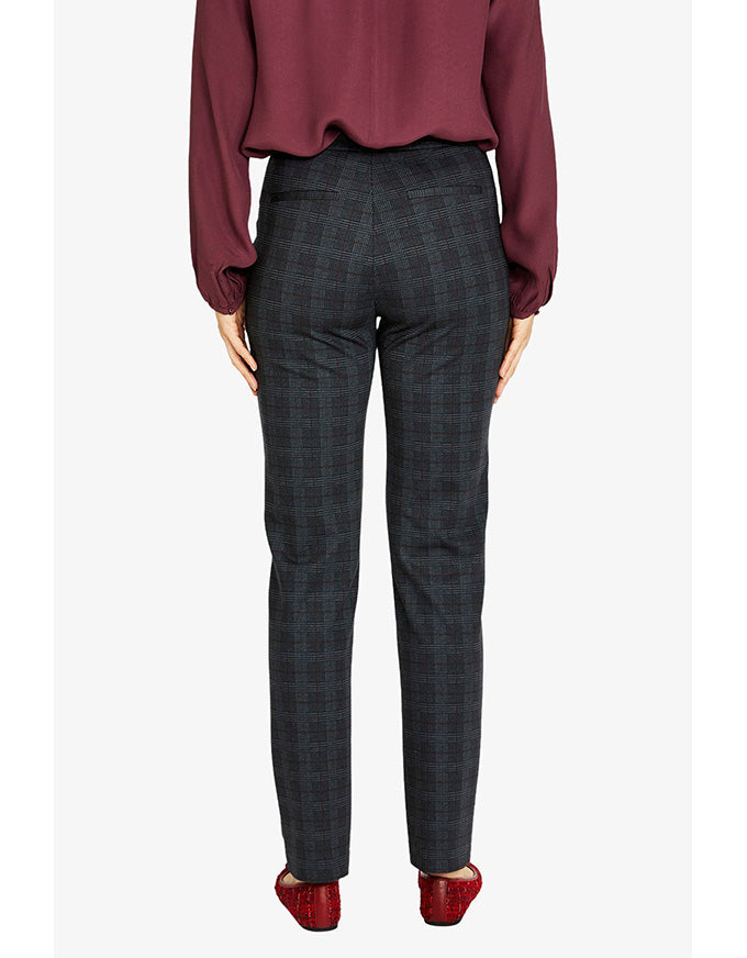 Person wearing a burgundy blouse and gray checkered pants on a white background