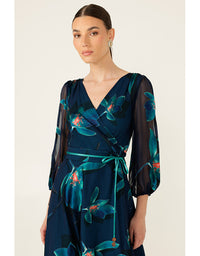 Woman wearing a dark blue dress with floral patterns on a white background