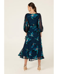 Woman wearing a navy floral dress on a white background