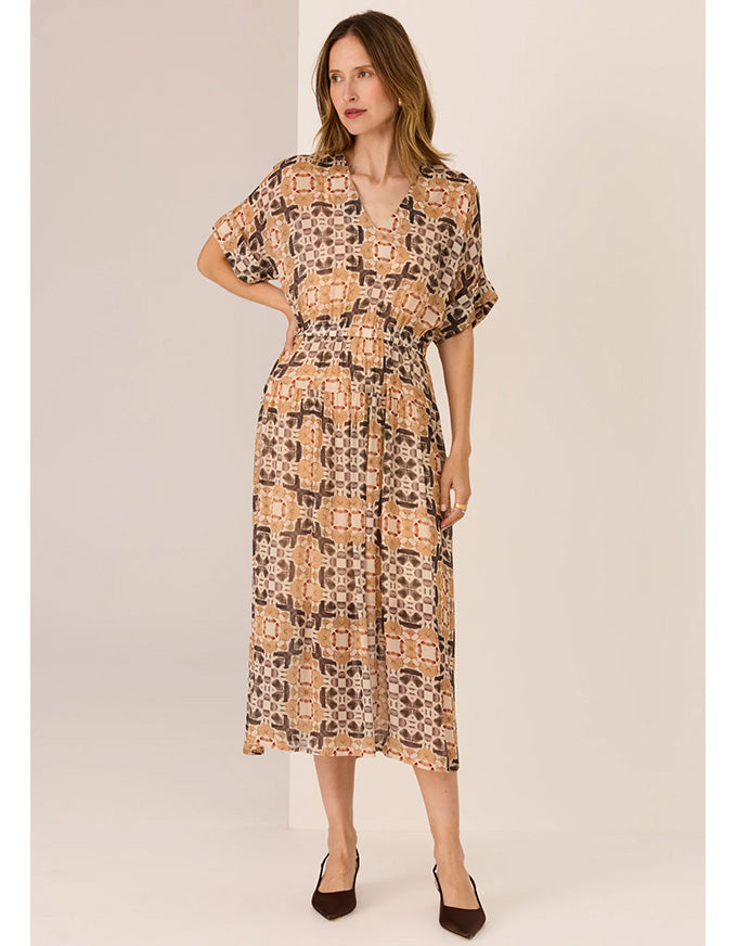 Woman wearing a patterned dress against a plain background