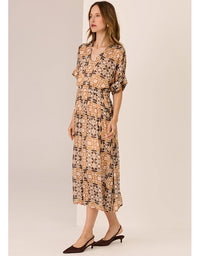 Woman wearing a patterned dress against a plain background