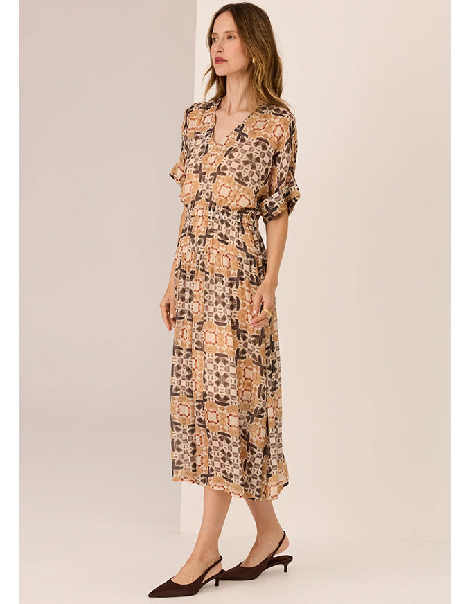 Woman wearing a patterned dress against a plain background