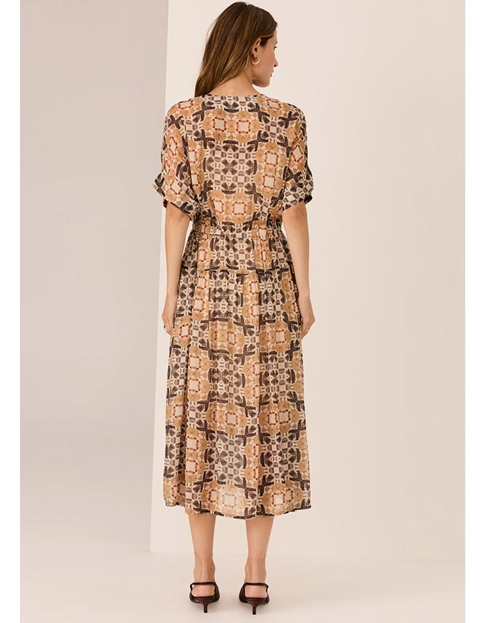 Woman wearing a patterned dress on a beige background
