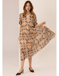 Woman wearing a patterned dress on a beige background
