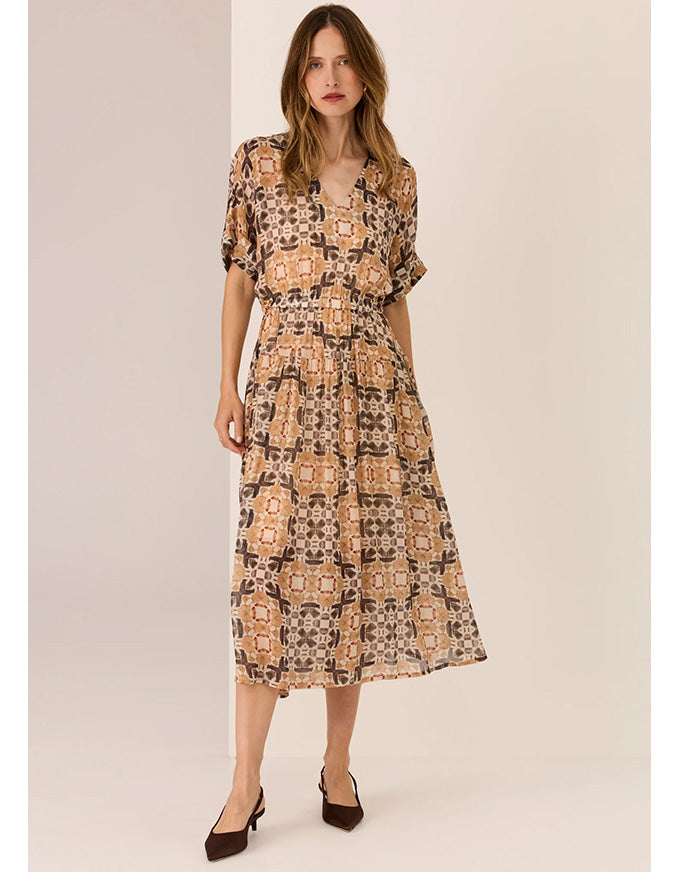 Woman wearing a patterned dress on a beige background