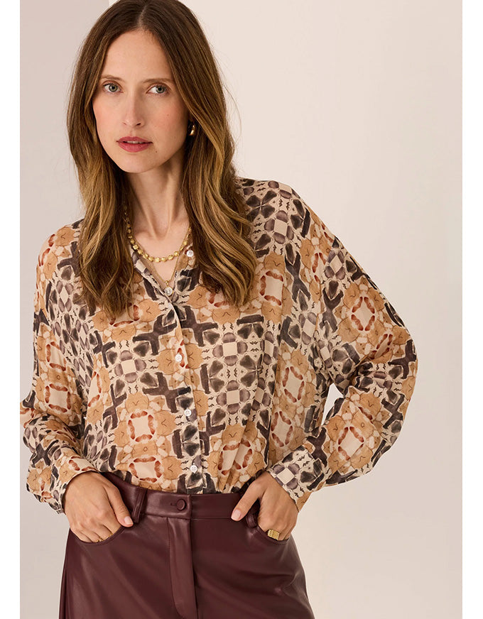 Woman wearing a patterned blouse with a plain background